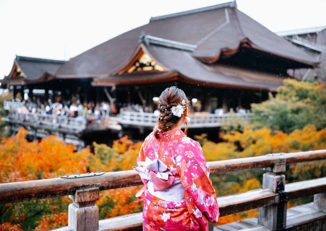 Japán nő kimonóban sétál az őszi fák között, Japán