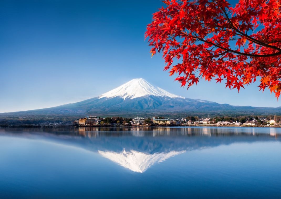 Fuji-hegy az őszi, vöröslő juharlevelek mögött, Japán