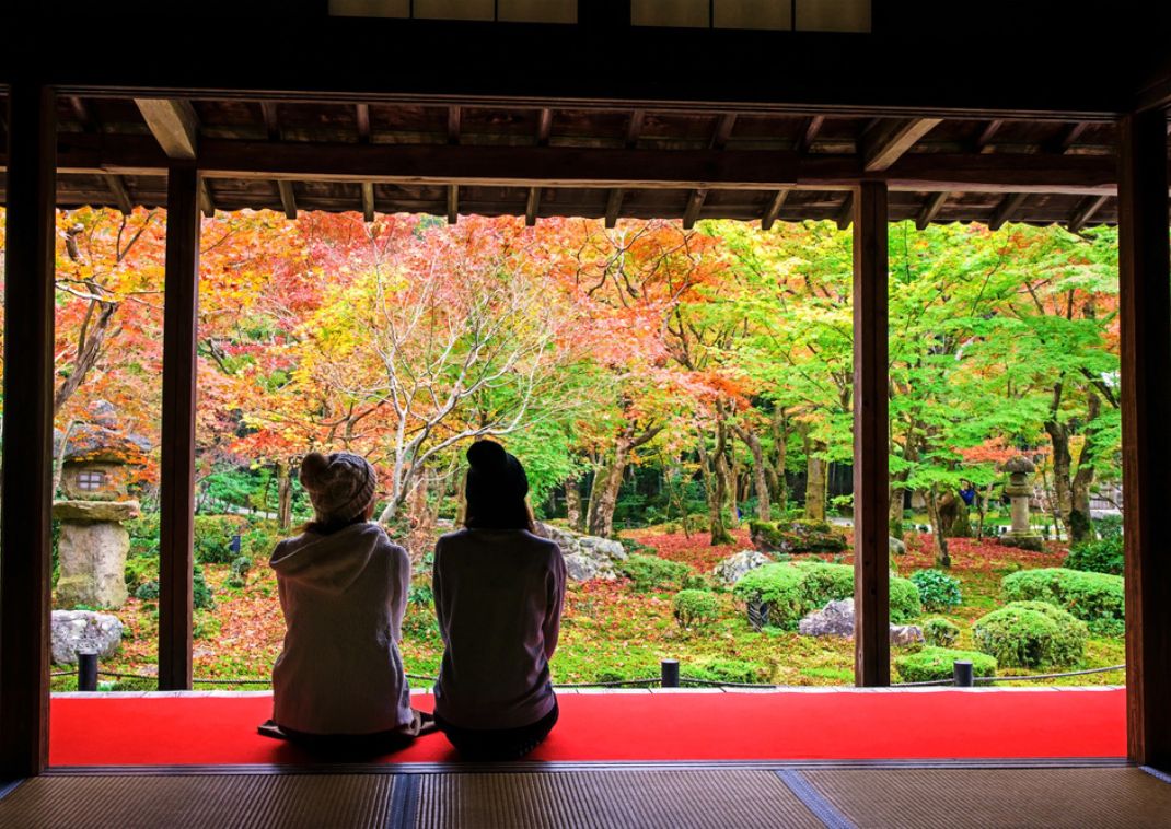 Két fiatal szemléli az Enkoji templom kertjét Kiotóban, Japán