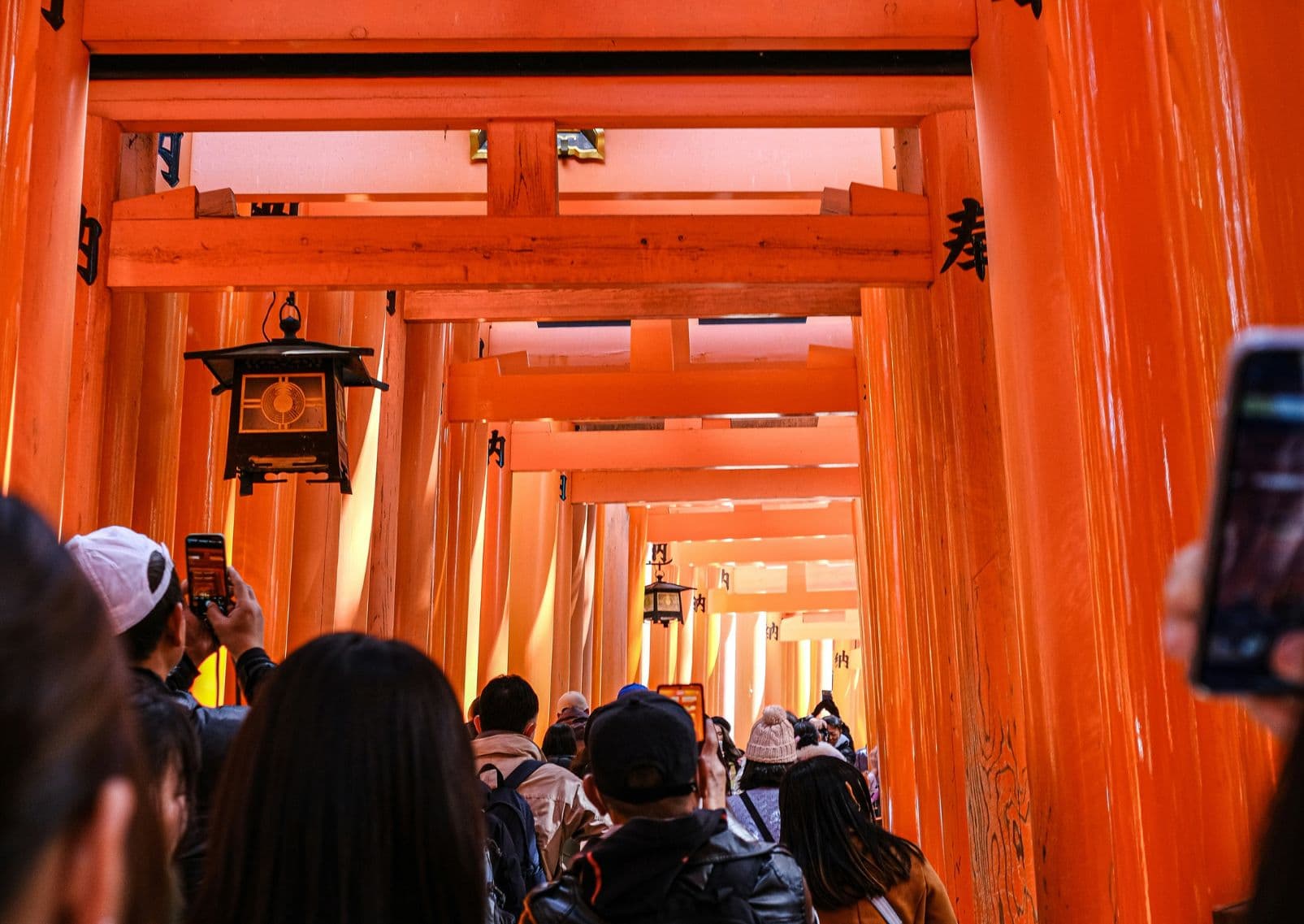 Turisták a Fushimi Inari szentély torii kapui alatt, Kiotó, Japán