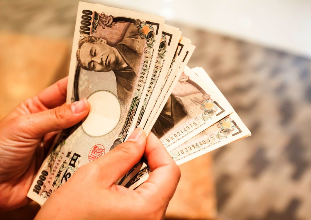 Japán jen bankjegyeket számoló személy