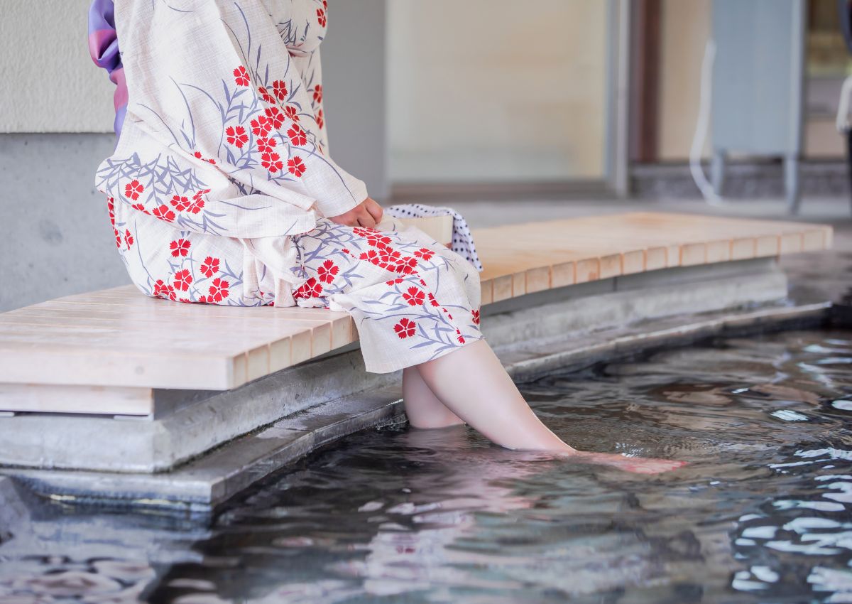 Japán yukatát viselő nő lábfürdőzés közben Japánban