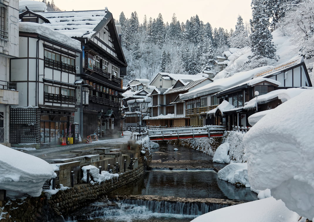 A téli Ginzan Onsen, a híres japán fürdőváros tipikus faépületei, egy alapos hóesés után