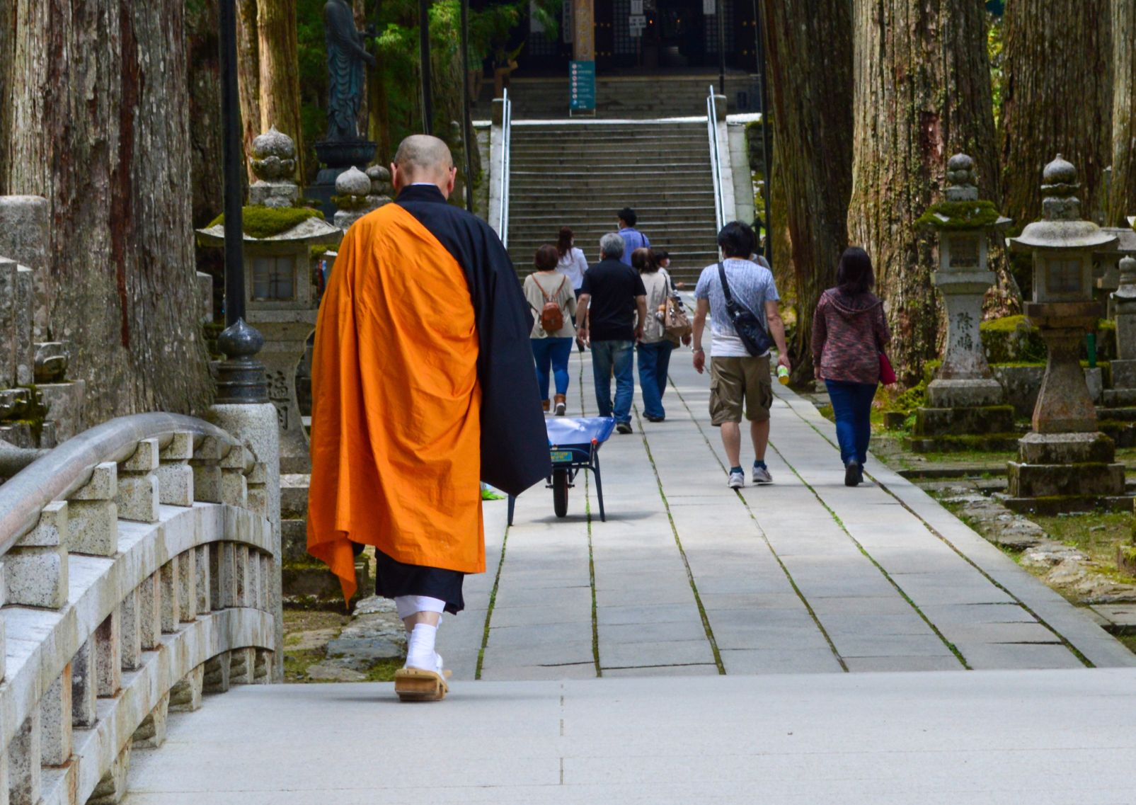 Buddhista szerzetes sétál egy templom felé a Koya hegyen, Japánban