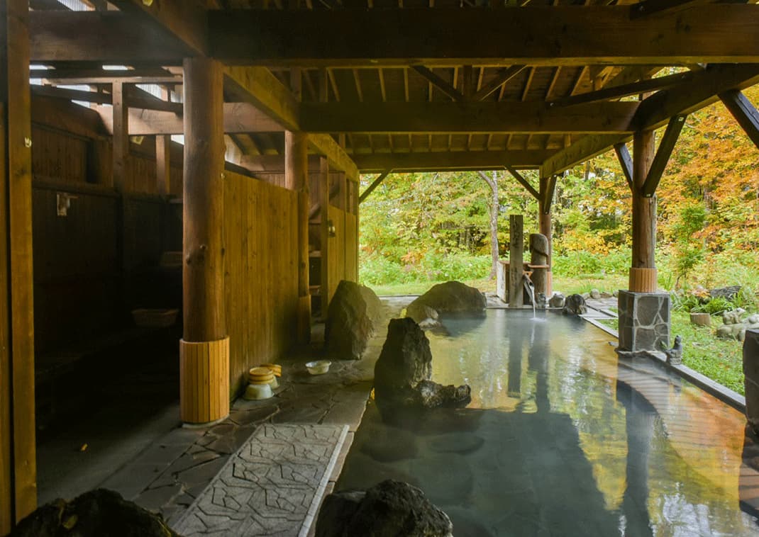 Smoky Outdoor Onsen (Hot Spring) in a Ryokan of Nyutou Forest, Akita, Japan Gőzölgő onsen a Nyuto-erdő egyik ryokanjában. Akita, Japán.