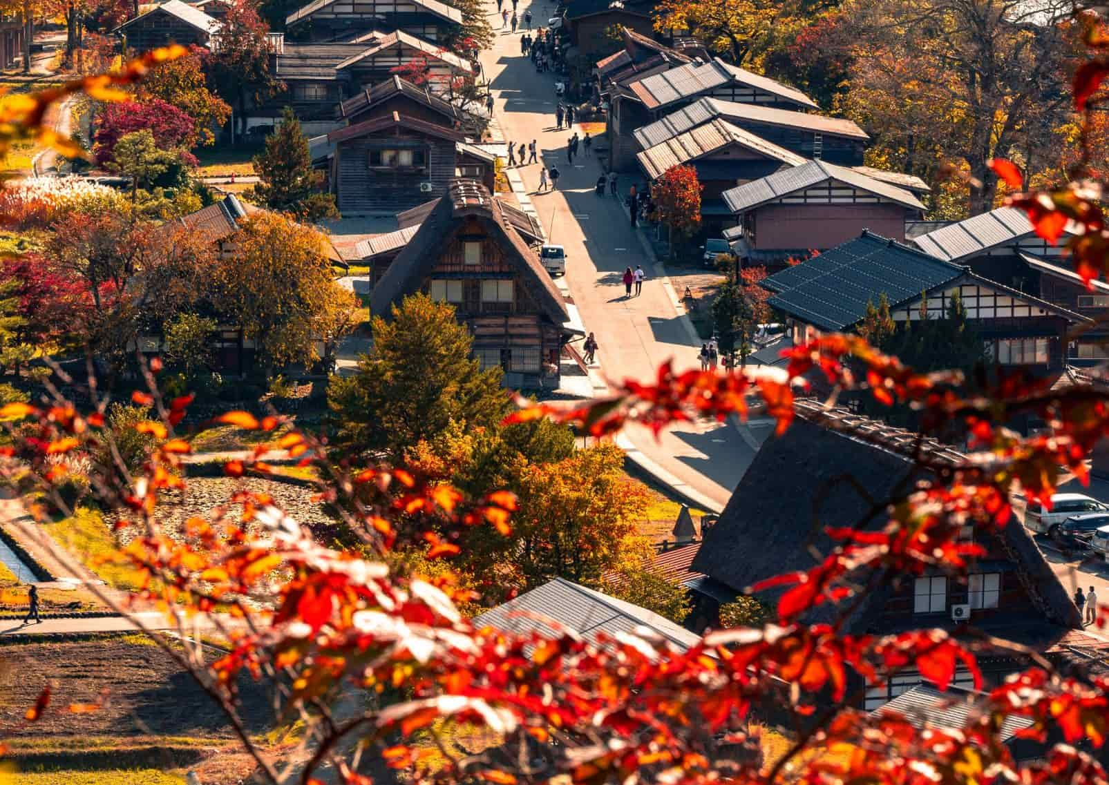 Shirakawago ősi falva az őszi lombok mögött