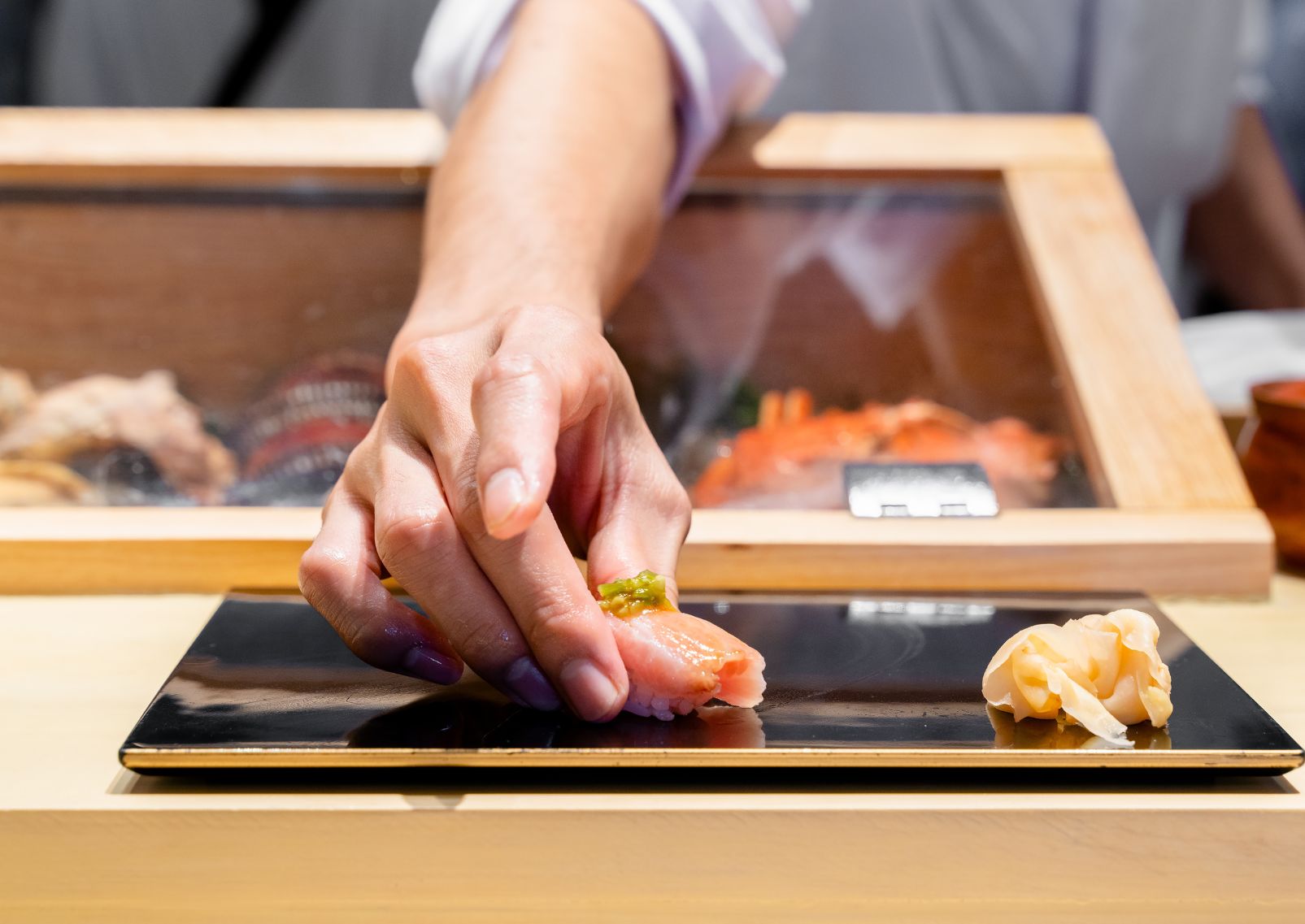 Szusi felszolgálása kézzel, hagyományos japán séf által