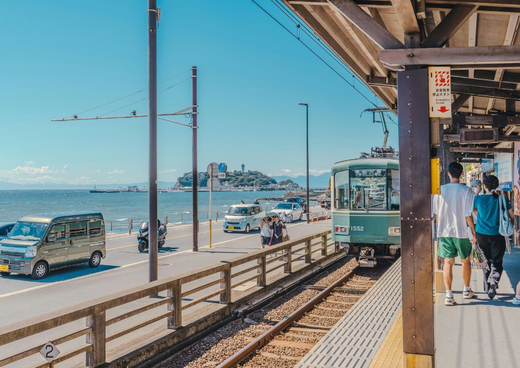 Turisták várakoznak a vonatra a tengerparti vasútállomáson Kamakurában, Kanagawa, Japán