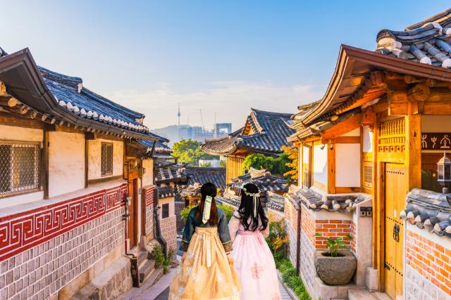 Bukchon hanok falu, háttérben a modern Szöullal 