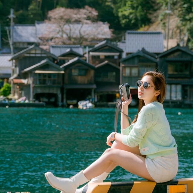 Fiatal nő pózol a kék tenger mellett Ine Funayában, Kiotó, Japán