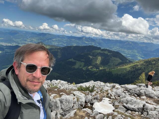 Alpesi hegycsúcson, panorámás kilátással a völgyre 