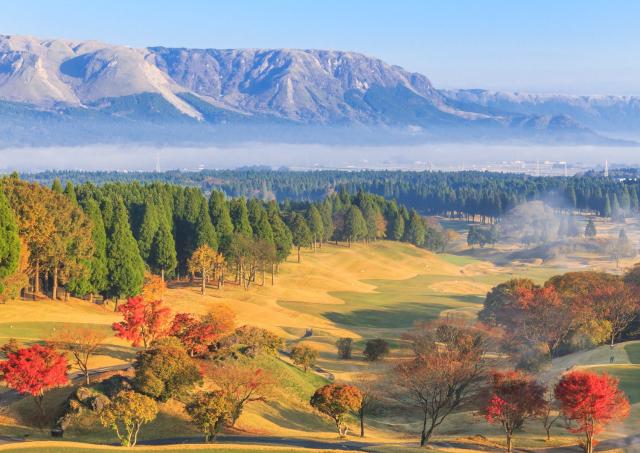 A látogatók golfozhatnak az Aso-hegy tövében