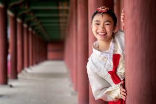 Korean lány tradícionális öltözetben a Gyeongbokgung Palotánál, Szöul, Dél-Korea